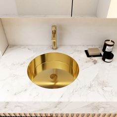 a bathroom sink with a gold faucet and marble counter top next to it