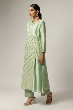 Green overlap kurta with embroidered floral motifs on yoke and sleeves hem. Paired with embroidered hem pant and floral embroidered scallop hem pink dupatta.
Components: 3
Pattern: Embroidered
Type Of Work: Floral
Neckline: Round
Sleeve Type: Full
Fabric: Silk Chanderi
Color: Green
Other Details: 
Scallop dupatta
Semi elasticated pant
Occasion: Puja - Aza Fashions Elegant Floral Embroidery Pant Set For Festive Occasions, Elegant Chanderi Pant Set With Chikankari Embroidery, Elegant Palazzo Set With Straight Kurta And Floral Embroidery, Anarkali Style Long Sleeve Pant Set With Chikankari Embroidery, Anarkali Straight Kurta Pant Set For Spring, Elegant Straight Kurta With Embroidered Sleeves, Elegant Pant Set With Zari Work And Long Sleeves, Elegant Anarkali Set With Embroidered Border For Spring, Elegant Spring Anarkali Set With Embroidered Border