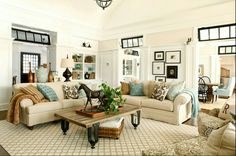 a living room filled with lots of furniture and decor on top of a white rug