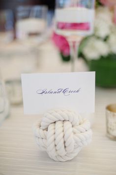 there is a place card holder made out of rope on top of a white table