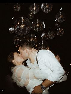 a man and woman kissing in front of disco balls