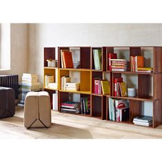 the bookshelf is made out of wood and has several different colored boxes on it