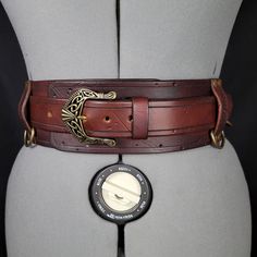 Choose Brown/ or black 3" Inch Leather belt for Viking, Cosplay or Larp costuming.  Hang sword or ax frogs, mug, pouch or skirt rings. 4 D rings are available with a belt. (accessories not included) The top belt can be worn separately from its 3" backing. This is a standard version of this belt. A "Deluxe" model is available in another listing. Hand tooled and stamped 8 OZ leather. Dyed, Rivets, Rings, and Celtic Buckle. Made to order 1-2 week delivery. Celtic Belt, Viking Medieval, Viking Cosplay, Viking Tunic, Medieval Cosplay, Black Waist Belt, Viking Garb, Viking Belt, Role Play Costume