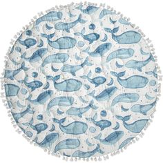 a round blue and white rug with whales on it