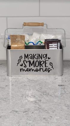 a metal container filled with lots of items on top of a marble countertop next to a white tile backsplash