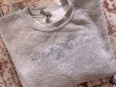 a t - shirt with the word west plains embroidered on it sitting on a rug