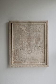 a white frame hanging on the wall above a toilet in a room with no walls