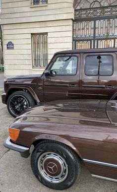 a brown truck parked in front of a building next to another vehicle on the street