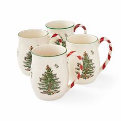 three mugs with christmas trees on them and candy canes in the bottom one