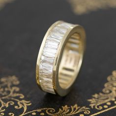 a close up of a wedding ring on top of a book with gold trimming