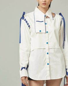 Description: A buttoned down white shirt with details that makes it a very unique shirt. Details like an asymmetrical collar with a pocket, a cut on the left shoulder, belt on the cuff, detachable modular sleeves, slit on the side seams and piping on the back makes it a very unusual but wearable shirt. Material details: Shirt Shell fabric: Certified organic cotton. Fastenings: Shirt: Wooden buttons Colour: Off white Sizing: • Fits true to size • Shirt: Designed for a regular fit • Medium weight Modular Clothing Fashion, Detachable Clothing, Modular Clothing, Modular Fashion, Detachable Clothes, Galaxy Makeup, Asymmetrical Collar, Luxury Sustainable, Mode Kimono