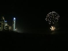 fireworks are lit up in the night sky above a large cityscape with skyscrapers