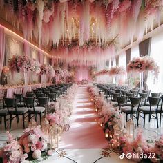 a room filled with lots of tables and chairs covered in pink floral decorations on the ceiling