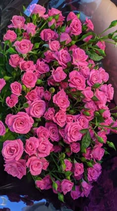 a bouquet of pink roses sitting on top of a table