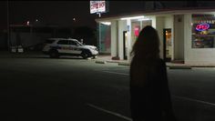 a police car is parked in front of a fast food restaurant at night with its lights on