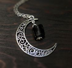 This beautiful crescent moon necklace will inspire all your moonlit nights. This made to order necklace features silver toned metals and a black tourmaline gemstone. product details Silver tone metals Choose your chain length Black tourmaline gemstone; Each piece is unique. The stone varies but is roughly 1/4 inch long or smaller. Each stone is natural and unique. Metaphysical properties of black tourmaline: One of the only stones that heals and protects on all levels, physical, mental, spiritua Goth Necklace, Crescent Moon Necklace, Creating Jewelry, Tourmaline Gemstone, Buy Handmade, Black Tourmaline, Moon Necklace, Crescent Moon, Healing Stones