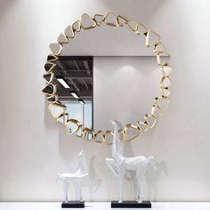 a mirror that is sitting on top of a table next to a horse statue in front of it