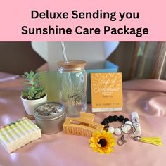 the contents of a care package on a bed with text overlay that reads, deluxe sending you sunshine care package