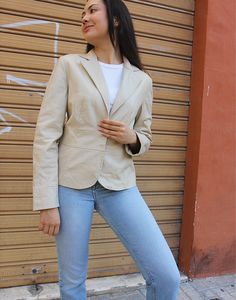 Leather blazer in cream. Snap fastenings. Size M.EU 38-42 / UK 10-14. Measurements - 38"(97cm) bust - 25"(64cm) sleeve length - 24"(61cm) jacket length. Material - Real leather. Condition - Excellent. Sustainability - Vintage. Handpicked, repaired and ready to wear. This is an original vintage item, not new and minor signs of wear and age are expected, we will highlight any major flaws. Model is a UK 6/8 and is 5'7" tall Tailored Cream Blazer For Work, Beige Fitted Blazer For Workwear, Fitted Beige Blazer For Work, Beige Formal Blazer For Spring, Cream Business Blazer With Lapel Collar, Fitted Beige Outerwear For Office Wear, Cream Fitted Blazer For Business Casual, Fitted Cream Blazer For Business Casual, Fitted Beige Blazer With Single Button