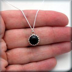 A lovely 10mm black onyx cabochon is set off to perfection in a sterling silver setting. The gallery wire bezel setting plays on the stone's classic beauty and creates a beautiful eye-catching necklace. Easily your go-to everyday necklace. Setting and curb chain are sterling silver. My black onyx earrings can be found here: https://www.etsy.com/listing/162000490/black-onyx-earrings-sterling-silver Jewelry is packaged in a cotton lined box for gift-giving. See more Bonny Jewelry at http://bonnyje Minimalist Round Cabochon Necklaces, Minimalist Round Cabochon Necklace, Black Jewelry With Bezel Setting For Gift, Onyx Cabochon Jewelry Gift, Black Round Pendant Jewelry With Cabochon, Nickel-free Black Necklace For Everyday, Black Cabochon Round Pendant Jewelry, Black Sterling Silver Birthstone Jewelry, Black Sterling Silver Jewelry With Birthstone