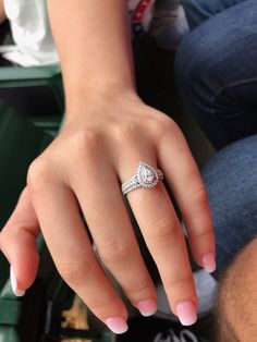 a close up of a person's hand with a diamond ring on their finger