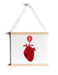 a red heart hanging on a white wall