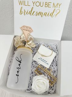 a bridesmaid gift set in a white box with gold accents and a rose