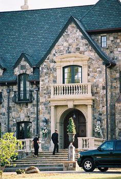 a car parked in front of a large stone house