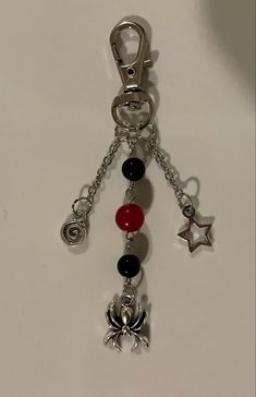 a key chain with various charms hanging from it's sides on a white surface