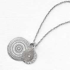 a coin necklace that revives the layered style. our double medallion pendant has two hand-stamped patterned coins strung on an 18" chain, ideal for layering with others in our medallion collection. materials + dimensions sterling silver to brighten, polish with a clean cloth avoid all chemicals + abrasives Nickel-free Sterling Silver Medallion Necklace, Sterling Silver Medallion Charm Necklace With Coin Pendant, Bohemian Necklace With Coin Pendant Medallion, Sterling Silver Coin Pendant Charm Necklaces, Nickel-free Round Pendant Coin Necklace In Amulet Style, Medallion Locket Charm Necklace In Amulet Style, Sterling Silver Medallion Locket Necklace, Amulet Style Medallion Necklace With Coin Pendant, Sterling Silver Medallion Necklace