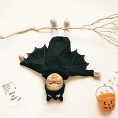 an overhead view of a halloween decoration with bats and pumpkins on the table, including a doll