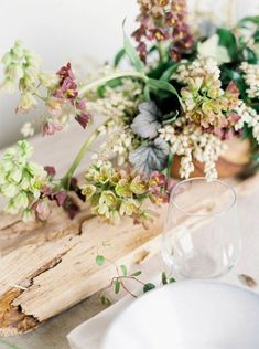 the table is set with white plates and flowers