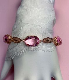 "Made To Order This is a brand new beautiful Edwardian/Art Deco reproduction solid sterling silver with rose gold plating filigree simulated pink topaz gemstone bracelet. The gemstones are approx. 15ctw (3 stones, 5 each) gemstones are 14mm by 10mm in L & W. The bracelet is 8.5 inches long at max, fits 7\" to 8.5\". Notice the beautiful floral craftsmanship of the filigree settings and links. A gift-box is included for safe shipping. Feel free to ask questions and thanks for looking at my li Victorian Rose Gold Bracelets As Gift, Victorian Rose Gold Bracelets Gift, Adjustable Oval Jewelry For Party, Rose Gold Oval Link Wedding Jewelry, Oval Rose Gold Bracelets For Formal Occasions, Adjustable Oval Party Jewelry, Elegant Pink Faceted Bracelet, Rose Gold Oval Bracelets For Wedding, Pink Oval Victorian Jewelry