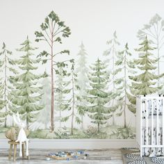 a baby's room with a wall mural that has trees on it