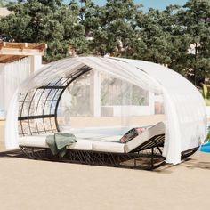 a bed sitting on top of a sandy beach next to a swimming pool with a canopy over it