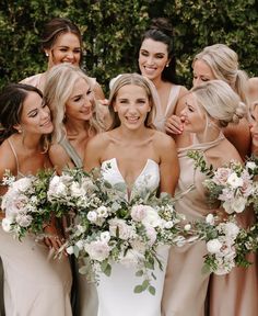 a group of women standing next to each other with bouquets in front of them