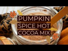 pumpkin spice hot cocoa mix in a glass jar with an orange spoon on top and the words pumpkin spice hot cocoa mix above it