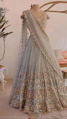 a mannequin is dressed up in a silver lehenga with gold sequins