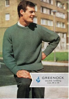 a man in a green sweater is standing on the street with his hands on his hips