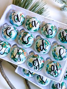 twelve christmas baubles with hand painted designs and the letters c, d, e, s