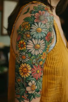 a woman's arm with flowers and leaves on the back of her body,