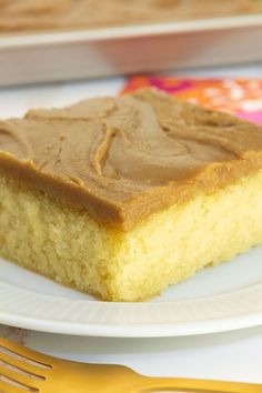 a piece of cake sitting on top of a white plate next to a yellow fork