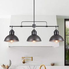 three lights hanging over a kitchen sink