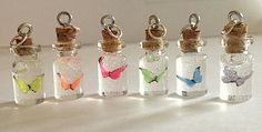 six glass bottles with different colored butterflies in them