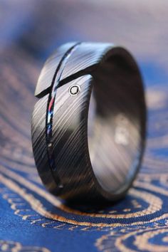 *new  Niobium/ Zirconium damascus ring body with a titanium /zirconium damascus (timascus) inlay. AAAA natural black diamond set with 14k white gold. This was ordered and seen here at 9mm wide. Size, width and diamond placement are customizable.   This ring can also be found on JBlunt Design's website at https://www.jbluntdesigns.com Black Etched Rings For Formal Occasions, Formal Black Etched Rings, Engraved Titanium Jewelry For Weddings, Engraved Titanium Wedding Jewelry, Wedding Engraved Titanium Jewelry, Jewelry Rings Unique, Meteorite Wedding Band, Mens Ring Designs, Diamond Ring Unique