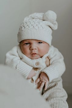 Indulge in the charm of our Oat Cable Knit Hat, meticulously crafted in 100% organic cotton with a stunning lattice cable stitch design. Adorned with a delightful pompom and our iconic scallop edge, this timeless accessory is breathable, thermoregulating, and exceptionally soft. Fits: Newborns up to 3 months. Composition: GOTS-certified 100% Organic Cotton. Soft, safe, and gentle on your baby's skin. Our baby knitwear won the Prestigious Platinum Award for 'Best Organic Clothing Brand' in the 20 Heirloom Baby Gifts, Knitted Baby Hat, Knit Romper, Baby Knitwear, Cable Knit Hat, Baby Bundles, Baby Hats Knitting, Cable Stitch, Organic Baby Clothes