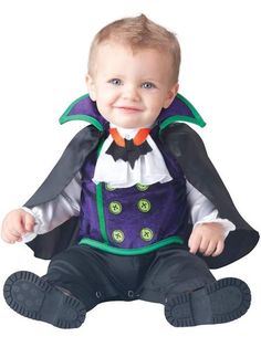 a baby dressed up as a joker sitting on the ground with his hands in his pockets