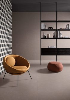 a chair and ottoman in a room with bookshelves on the wall behind them