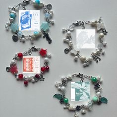 three bracelets with pictures and charms attached to them on a gray surface, one is red, the other is green