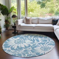 a living room filled with furniture and a large rug on top of a hard wood floor